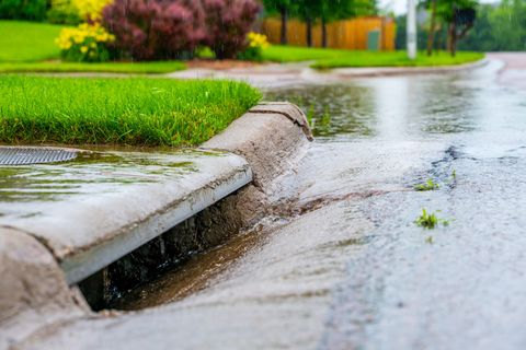 Rainwater running off a road into a highway gully
