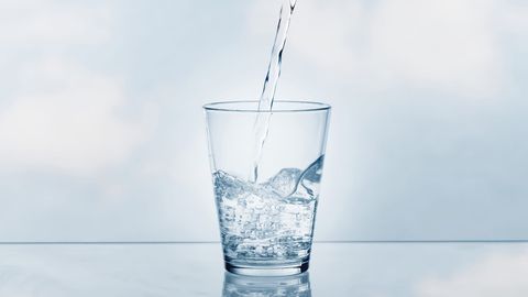 Water pouring into a clear glass