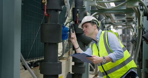 An engineer inspecting mechanical and electrical plant equipment